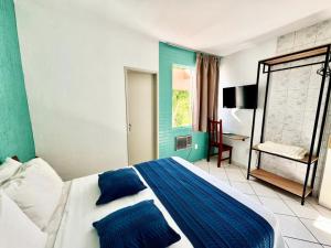 a bedroom with a blue and white bed and a desk at Big Hotel Florianópolis in Florianópolis