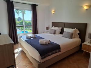 a bedroom with a large bed with a large window at Clube Alvor Ria - Waterfront luxury apartments with stunning views in Alvor +35 photos