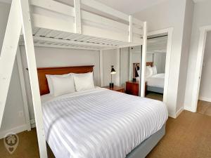 a bedroom with a white bunk bed and a mirror at Silver Rock by StayIn in Fernie