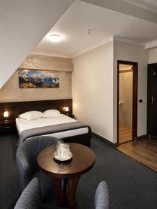 a hotel room with a bed and a table at Pensiunea La Busu in Bran +155 photos