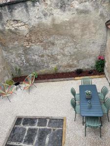 a patio with a blue table and chairs at Maison Oria in Souvigny