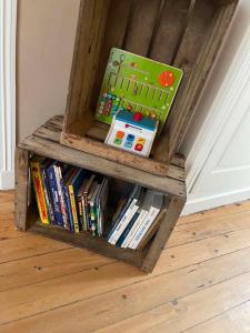 a book shelf filled with books on a wooden floor at Maison Oria in Souvigny