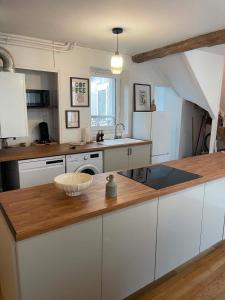 a kitchen with white cabinets and a wooden counter top at Maison Oria in Souvigny