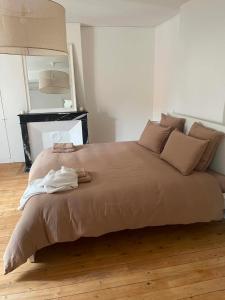 a bedroom with a large bed with towels on it at Maison Oria in Souvigny