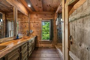 a bathroom with wooden walls and a sink and a window at Sky's the Limit in Mineral Bluff +63 photos