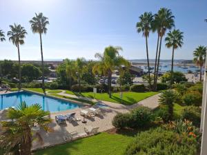 an aerial view of a swimming pool and palm trees at Clube Alvor Ria - Waterfront luxury apartments with stunning views in Alvor