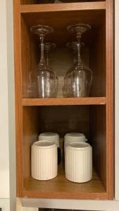 a wooden shelf with bowls and glass dishes on it at Nomads nest suites in Kiambu