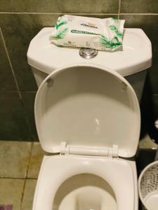 a toilet in a bathroom with a roll of toilet paper at Nomads nest suites in Kiambu +53 photos