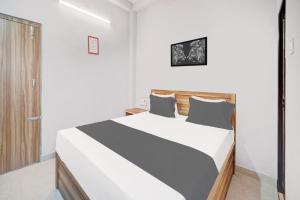 a bedroom with a bed in a white room at Super HOTEL O ROYAL GUEST HOUSE in Rānchī