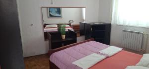 a bedroom with a bed and a dresser and a mirror at Apartman Villy 2 in Jadranovo