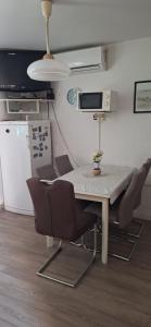 a kitchen with a table with chairs and a refrigerator at Apartman Villy 2 in Jadranovo