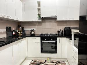 a white kitchen with white cabinets and an oven at Iconic Galaxy in Rajagiriya +1 photo