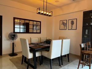 a dining room with a table and white chairs at Iconic Galaxy in Rajagiriya