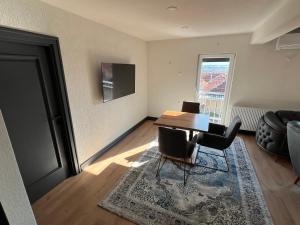 a living room with a table and chairs and a couch at Panorama Residence Apartments in Kumanovo