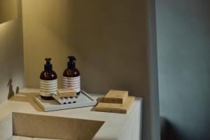 two bottles sitting on a shelf in a bathroom at Amorgina in Amorgos