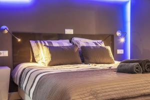 a bedroom with a large bed with purple lighting at The Orange Canals Suite in Amsterdam