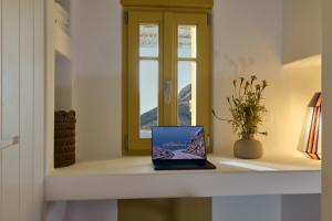 a laptop sitting on a shelf next to a window at Amorgina in Amorgos
