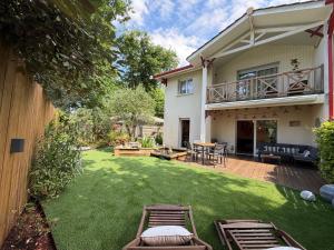 a yard with chairs and a patio with a house at Le Gahignon in Lanton