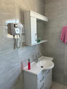 a bathroom with a sink and a hair dryer at Suite Privativa in Dom Pedrito +28 photos