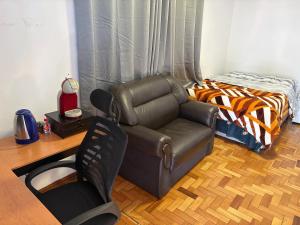 a living room with a couch and a bed at Suite Privativa in Dom Pedrito