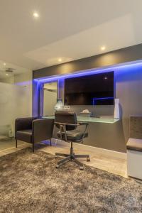 an office with a desk and a chair and blue lighting at The Orange Canals Suite in Amsterdam +23 photos