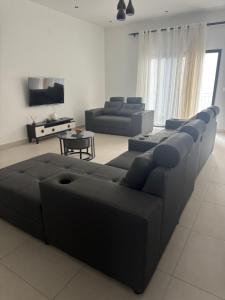 a living room with a couch and a tv at Flora House in Maputo