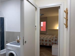 a bathroom with a room with a bed and a washing machine at 5 Terre in Lerici