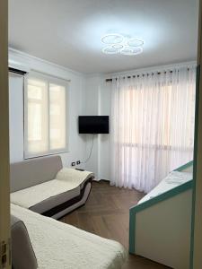 a room with a couch and a tv and a window at Bamisa Apartments in Golem