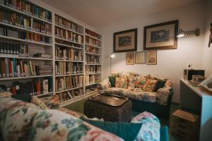 a living room with a couch and book shelves at Antica Dimora Del Gruccione, Albergo diffuso in Santu Lussurgiu
