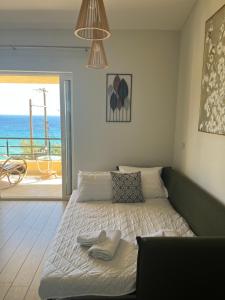 a bedroom with a bed with a view of the ocean at Daphne Glyfada Corfu in Glyfada