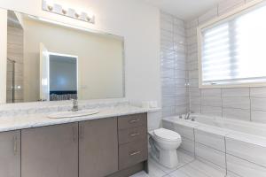 a bathroom with a sink and a toilet and a mirror at Home in Waterdown in Hamilton +46 photos