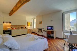 a large bedroom with a white bed and a kitchen at Palazzo Gritti in Morcote