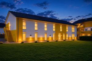 a large white house with a lawn at night at i-Motel Obertshausen nahe Frankfurt in Obertshausen