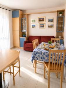 ein Wohnzimmer mit einem Tisch und einem roten Sofa in der Unterkunft Residence Garbin - Agenzia Cocal in Caorle