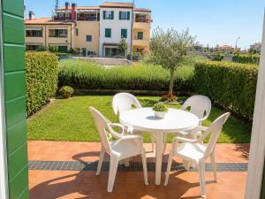 ein weißer Tisch und Stühle auf einer Terrasse in der Unterkunft Residence Garbin - Agenzia Cocal in Caorle