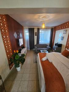 a hotel room with two beds and a living room at Pinnacle Homes 254 - Kamakis in Ruiru