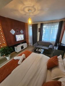 a bedroom with a large bed and a couch at Pinnacle Homes 254 - Kamakis in Ruiru +2 photos