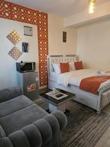 a hotel room with a bed and a couch at Pinnacle Homes 254 - Kamakis in Ruiru