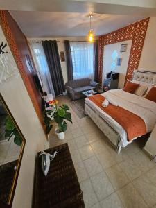 a bedroom with a large bed and a living room at Pinnacle Homes 254 - Kamakis in Ruiru
