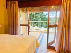 a bedroom with a bed and a sliding glass door at The Social in Burgersfort