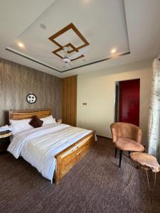 a bedroom with a large bed and a chair at Mariner Lodge Skardu in Skardu