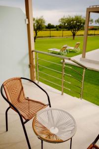 a rattan chair and a table on a balcony at Aura Otto Luxury Living in Alexandroupoli