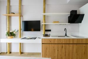 a kitchen with a sink and a tv on a counter at Aura Otto Luxury Living in Alexandroupoli