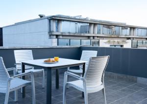 a table and chairs on top of a balcony at Airhostel Barcelona Airport 24h in El Prat de Llobregat