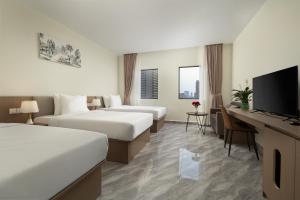 a hotel room with two beds and a flat screen tv at Amana Hotel Phnom Penh in Phnom Penh +42 photos