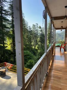 a porch of a house with a view of the forest at Trio Nest in Jibhi