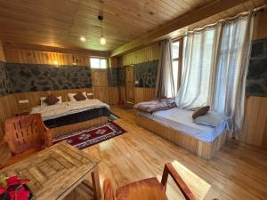 a room with two beds and a table in a cabin at Trio Nest in Jibhi +22 photos