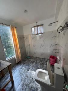 a bathroom with a toilet and a sink at Trio Nest in Jibhi