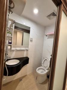 a small bathroom with a toilet and a sink at Calm & Comfy at Sky House BSD in Cilenggang