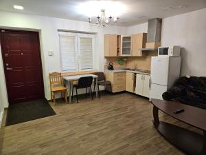 a kitchen and living room with a table and a refrigerator at Centro bustas in Kėdainiai